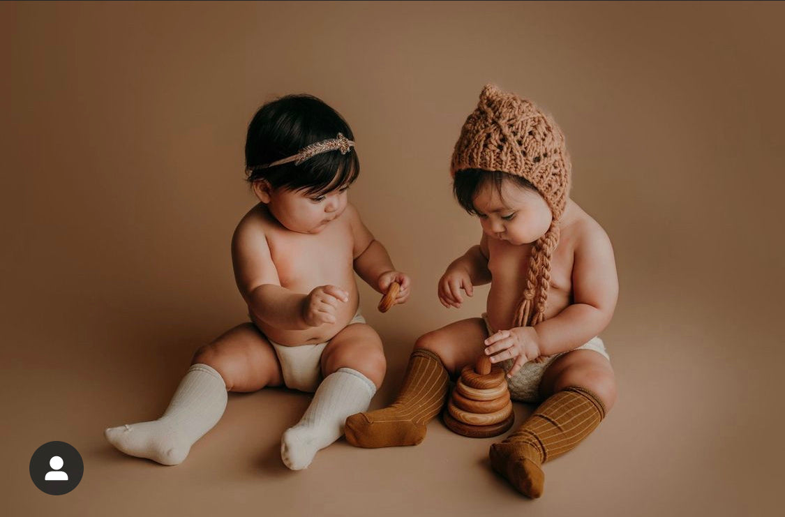one year twin girls sitting for their first birthday milestone photoshoot